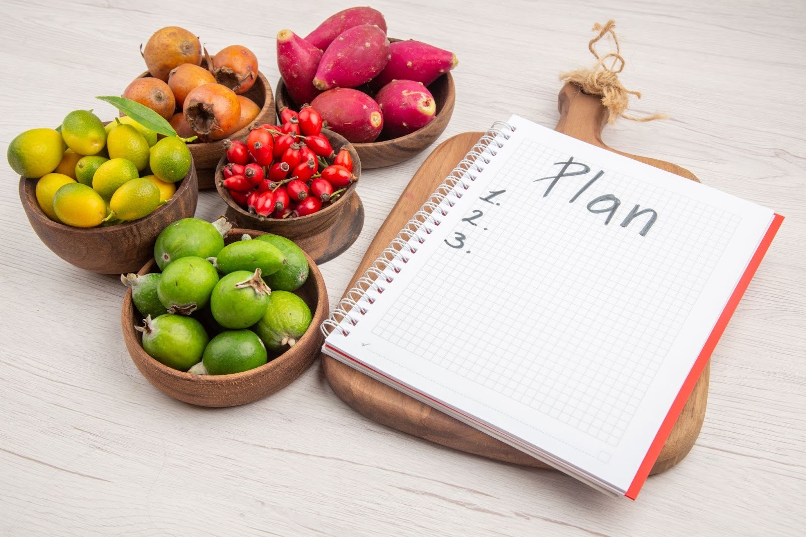 A notebook with the word plan written with fruit surrounding.