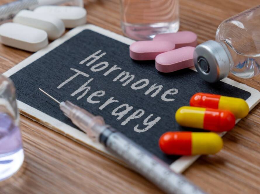 Hormone therapy is written on a chalk board with medications surrounding it.